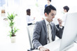 Businessman looking at the monitor of a personal computer with a cup of coffee Businessman looking at the monitor of a personal computer with a cup of coffee