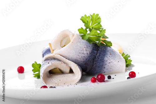 Zdjęcie XXL Rollmops (rolowany śledź marynowany) z marynowanym ogórkiem, solą, pieprzem i pietruszką, zbliżenie