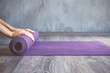 Woman rolling her mat after a yoga class Woman rolling her mat after a yoga class