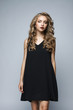 Beautiful girl in a black dress in the studio on a white backgro Beautiful girl in a black dress in the studio on a white backgro