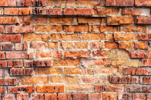 Weathered stained old orange brick wall, texture grunge background