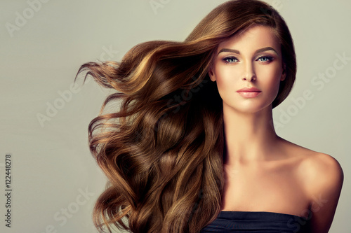 Beautiful model  girl with long wavy  and shiny  hair . Brunette woman  with curly hairstyle  © Sofia Zhuravetc