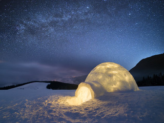 Winter night landscape with a snow igloo and a starry sky