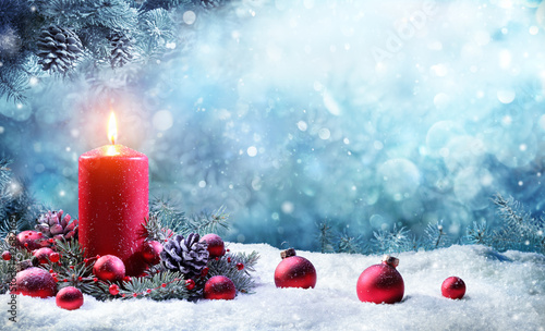 Advent Candle With Fir Branches Burning In Snowy Scene

