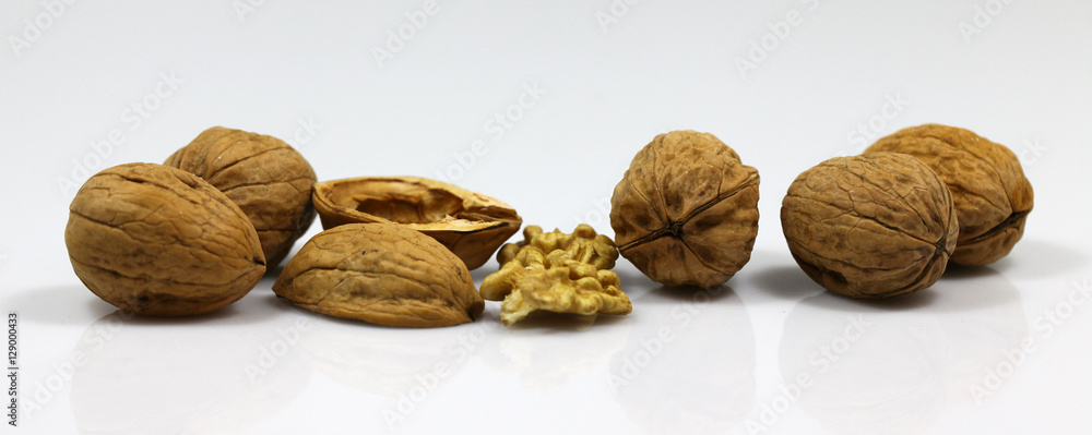 Walnut and a cracked walnut on the white background
