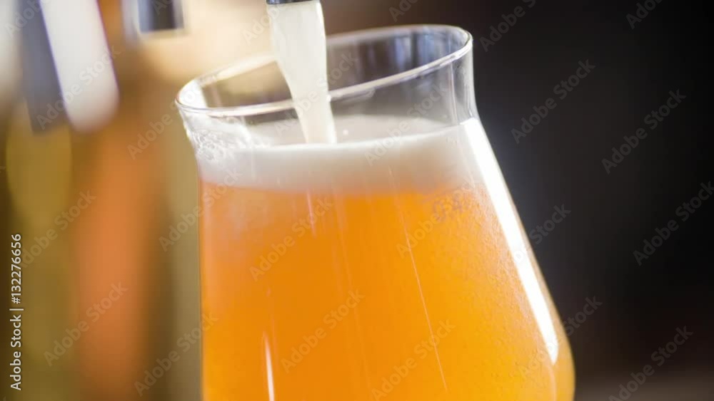 Craft beer pouring to glass in pub bar HD slow-motion video. Lager, ale or dunkel falls from a cask to stemware