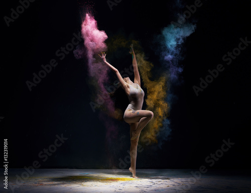 Obraz Fotograficzny Gymnast in ecru bodysuit with colored dust around