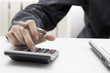 closeup of the hand with the calculator on the desktop closeup of the hand with the calculator on the desktop