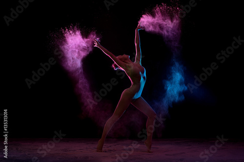 Obraz Fotograficzny Slender girl dancing in color powder cloud