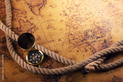 Fototapeta time for adventures - vintage compass and rope on old world map