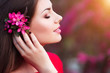 Spring touch. Happy beautiful young woman in red dress enjoy fresh pink flowers and sun light in blossom park at sunset. Spring touch. Happy beautiful young woman in red dress enjoy fresh pink flowers and sun light in blossom park at sunset.