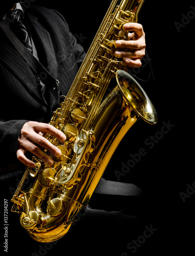 saxophone in male hands on a black background