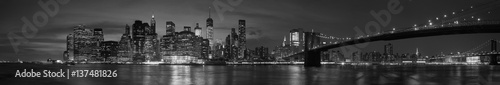 Fototapeta New York city with Brooklyn Bridge, iconic skyline panorama at night in black and white