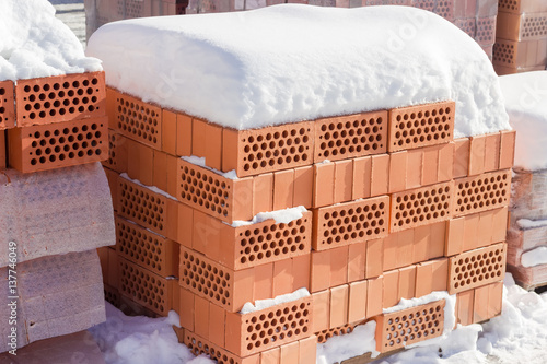 Pallets of the perforated red bricks on an outdoor warehouse