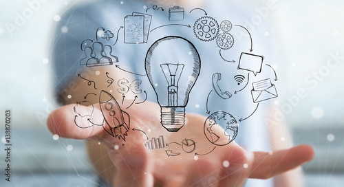 Businessman holding hand drawn lightbulb and multimedia icons