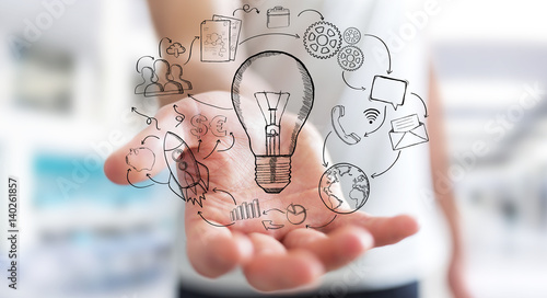 Businessman holding hand drawn lightbulb and multimedia icons