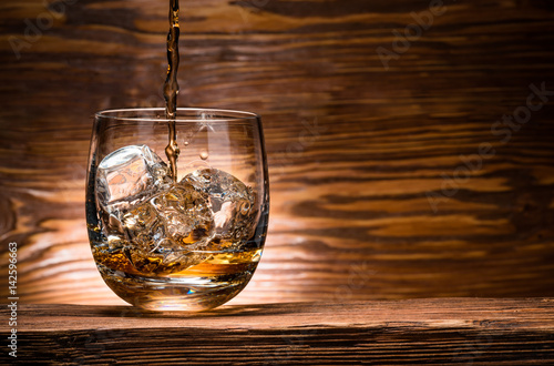 whiskey with ice on a wooden table