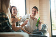 Cheerful young friends drinking wine and beer on sofa Cheerful young friends drinking wine and beer on sofa