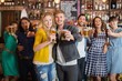 Cheerful friends holding beer glasses in pub Cheerful friends holding beer glasses in pub