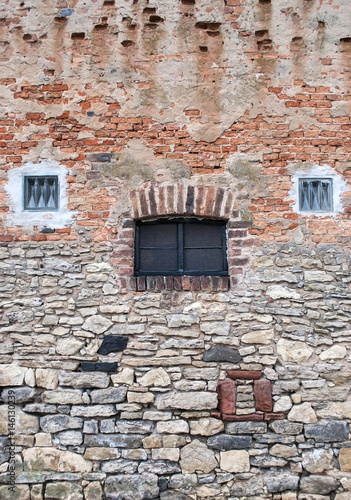 Sehr alte Steinmauer aus Backsteinen und Natursteinen mit "Gesicht", Textur, Hintergrund, Textfreiraum
