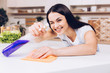 Woman in the kitchen is smiling and wiping dust using a spray and a duster while cleaning her house, close-up Woman in the kitchen is smiling and wiping dust using a spray and a duster while cleaning her house, close-up