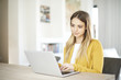 Home office. Shot of a smiling young woman working on laptop at home. Home office. Shot of a smiling young woman working on laptop at home.