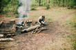 Young man preparing food at a campfire. Young man preparing food at a campfire.