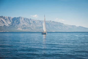 Sailing yacht in the sea against the backdrop of mountains