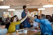 Creative business team giving a high five to each other Creative business team giving a high five to each other