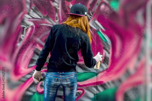 Zdjęcie XXL Młoda miejska dziewczyna rysuje graffiti, współczesna ikoniczna kultura ulicznej młodości. Nowoczesna kultowa ulica kultury miejskiej. Koncepcja nowoczesnego wzornictwa. Graffiti sztuki ulicy. selektywna ostrość