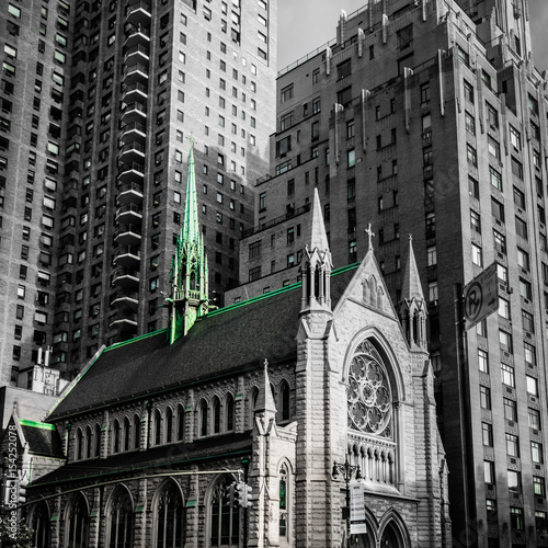 Fototapeta Church in New York Manhattan caught by the modern skyscrapers black white green