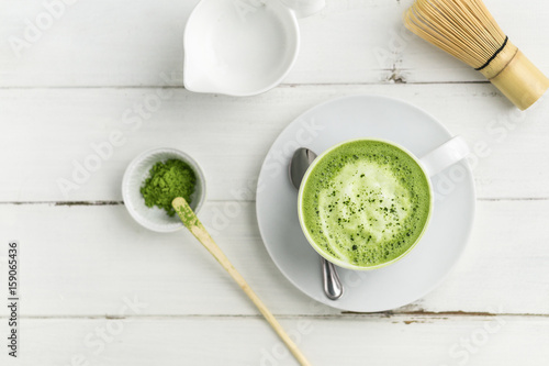 Fotoobraz na płótnie Matcha latte filiżanka na białego tła odgórnym widoku. Ta latte to pyszny sposób, aby cieszyć się energią i zdrowymi korzyściami matchy. Matcha to proszek liści zielonej herbaty z przeciwutleniaczami.