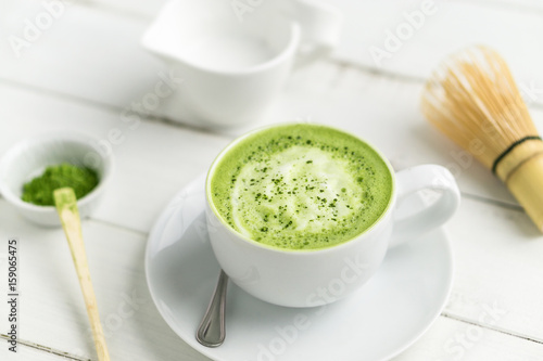 Fotoobraz na płótnie Filiżanka matcha zielonej herbaty latte z akcesoriami. Ta latte to pyszny sposób, aby cieszyć się energią i zdrowymi korzyściami matchy. Matcha to proszek liści zielonej herbaty z przeciwutleniaczami.