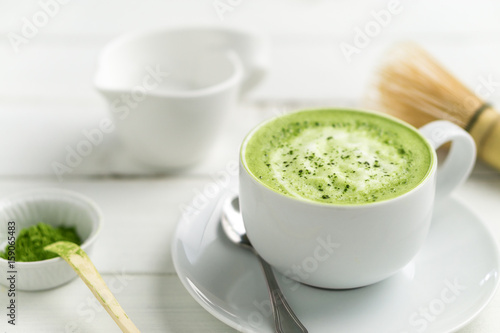 Fotoobraz na płótnie Matcha latte filiżanki zakończenie w górę tła zamazującego. Ta latte to pyszny sposób, aby cieszyć się energią i zdrowymi korzyściami matchy. Matcha to proszek liści zielonej herbaty z przeciwutleniaczami.