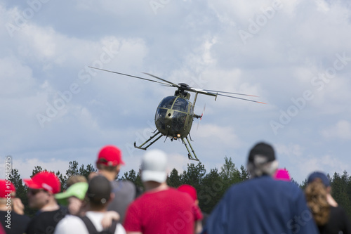Fotoobraz na płótnie Helikopter unoszący się przed ludźmi. Leci naprawdę nisko.