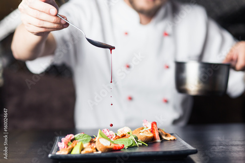 Fotoobraz na płótnie mężczyzna kucharzy przygotowuje mięso w kuchni restauracji