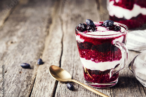 Plakat Zdrowe śniadanie: dżem z wiciokrzewu, muesli i twarogu parfait na rustykalne drewniane tła. Selektywna ostrość