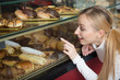 Young blond girl gladly selecting pastry Young blond girl gladly selecting pastry