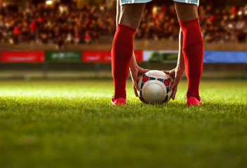 Soccer player with red socks preparing for free kick.