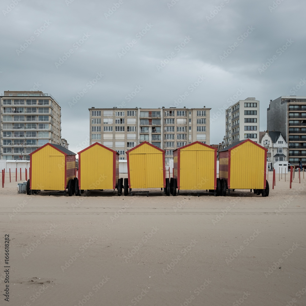 Row of colorful beach cabins on a cloudy day in De Panne, Belgium.