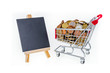 Shopping cart with pennies and black chalkboard to write on. Isolated on white background Shopping cart with pennies and black chalkboard to write on. Isolated on white background
