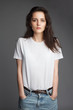 attractive female model front view in blank white t-shirt and jeans isolated on gray background attractive female model front view in blank white t-shirt and jeans isolated on gray background
