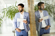 Smiling young businessman using his digital tablet at the office Smiling young businessman using his digital tablet at the office