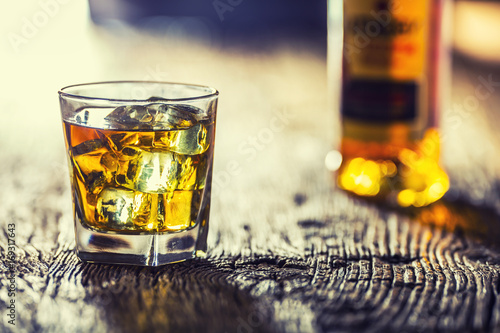 Plakat Whisky. Whisky pić z kostkami lodu na starym rustykalnym dębowym stole