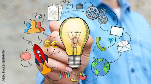 Businessman drawing a lightbulb with a pen with multimedia icons