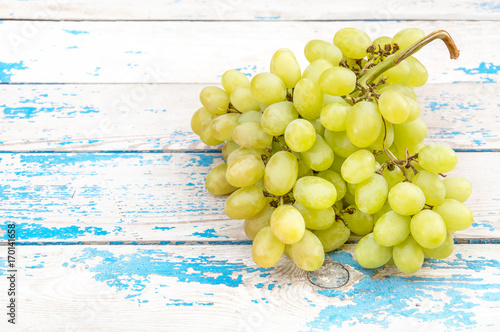 Bunch of fresh ripe green grapes on a old wooden table.