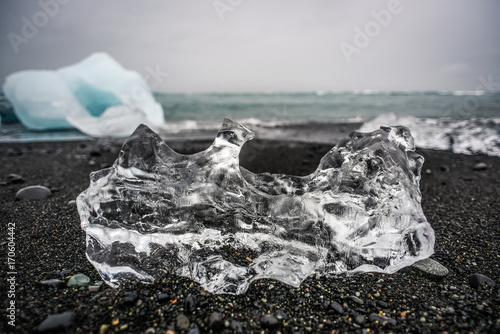 Plakat Prześcieradło leżące na czarnej plaży w Islandii, wybrzeża oceanu w pobliżu Jökulsárlón - lodowiec laguny.