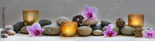 concept of wellbeing with pebbles, orchids and candles, panoramic concept of wellbeing with pebbles, orchids and candles, panoramic