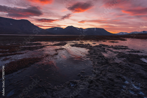 Landscape travel of a nature of a sunset sunrise with clouds in the mountains of Spitsbergen Svalbard near the Norwegian city Longyearbyen