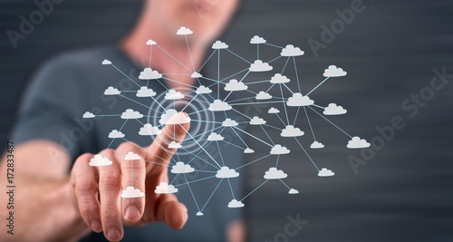 Man touching a cloud network on a touch screen